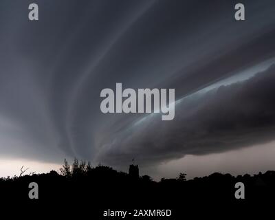 Nubi tempesta che si formano su Aldeburgh, Suffolk, Inghilterra con la Chiesa di San Pietro all'orizzonte Foto Stock