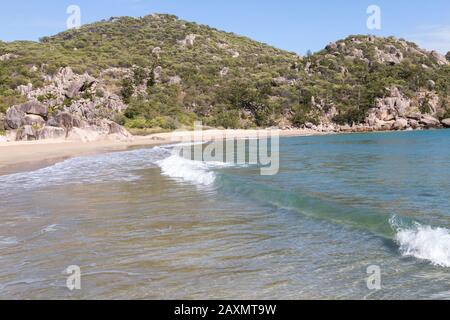 Piccole onde che si infrangono sulla spiaggia di sabbia chiara di Magnetic Island Foto Stock