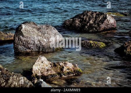 alcune rocce vicino alla riva in acqua, filtro Foto Stock