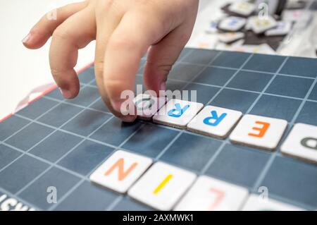 Pratiche del bambino con il gioco del bordo di formazione di parola. Il gioco è fatto con pezzi di lettera magnetica. Messa a fuoco selettiva Foto Stock