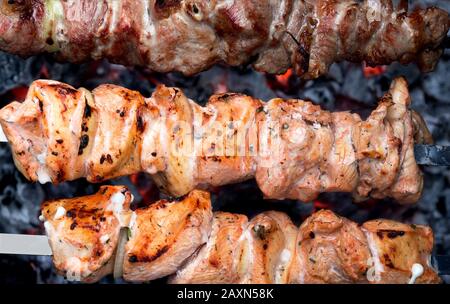 Barbecue. Manzo e maiale Shish kebab su spiedini fritti su carboni caldi. Primo piano di spiedini di carne. Spiedini barbecue kebab di carne. Foto Stock