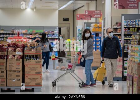 Gli acquirenti hanno visto indossare maschere facciali protettive mentre acquistano in un supermercato.Panic cresce a Hong Kong come la città ha confermato il caso 50th Di Nuovo coronavirus (2019-nCoV). Oltre 40.000 casi di virus hanno confermato in tutto il mondo, ha finora rivendicato oltre 1000 vite. Foto Stock