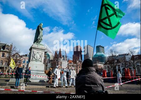 Un attivista XR che tiene una bandiera con il logo XR durante la protesta.Mentre il governo olandese ha un dibattito sul CETA, accordo di libero scambio, il gruppo attivista Extinction Rebellion Nederland ha svolto un'azione al di fuori delle Houses of Parliament per fare un appello a fermare l'accordo CETA. Oltre 70 organizzazioni in tutto il mondo hanno firmato una lettera aperta per chiedere al governo olandese di votare contro il CETA. Foto Stock