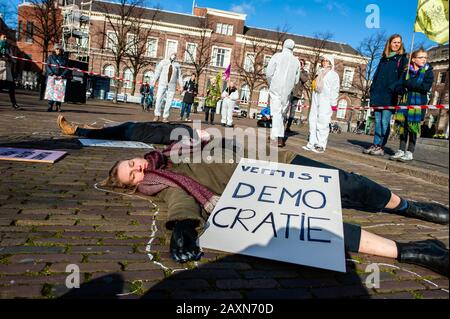 Un attivista XR che si esibisce mentre tiene un cartello durante la protesta.Mentre il governo olandese ha un dibattito sul CETA, accordo di libero scambio, il gruppo attivista Extinction Rebellion Nederland ha svolto un'azione al di fuori delle Houses of Parliament per fare un appello a fermare l'accordo CETA. Oltre 70 organizzazioni in tutto il mondo hanno firmato una lettera aperta per chiedere al governo olandese di votare contro il CETA. Foto Stock