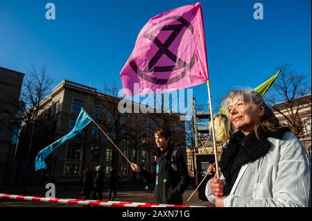 Un attivista che tiene una bandiera rosa della ribellione di estinzione durante la protesta.Mentre il governo olandese ha un dibattito circa CETA, accordo di libero scambio, il gruppo attivista Extinction Rebellion Nederland ha effettuato un'azione al di fuori delle Houses of Parliament per fare un appello per fermare l'accordo CETA. Oltre 70 organizzazioni in tutto il mondo hanno firmato una lettera aperta per chiedere al governo olandese di votare contro il CETA. Foto Stock