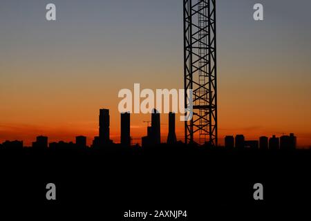 Immagine del tramonto nel quartiere di Valdebebas a Madrid. Area in costruzione con gru montate Foto Stock