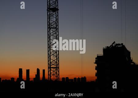 Immagine del tramonto nel quartiere di Valdebebas a Madrid. Area in costruzione con gru montate Foto Stock