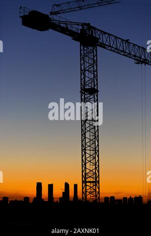 Immagine verticale del tramonto nel quartiere di Valdebebas a Madrid. Area in costruzione con gru montate Foto Stock