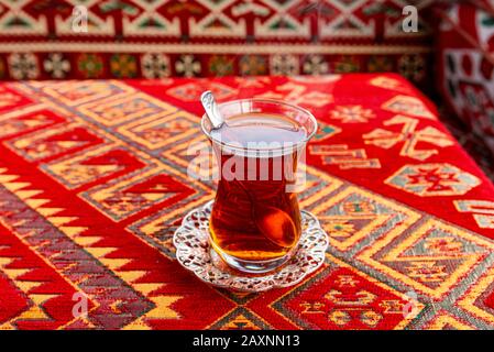 Hot Turkish Tea Cup su un tavolo con Tovaglia tradizionale turca Foto Stock
