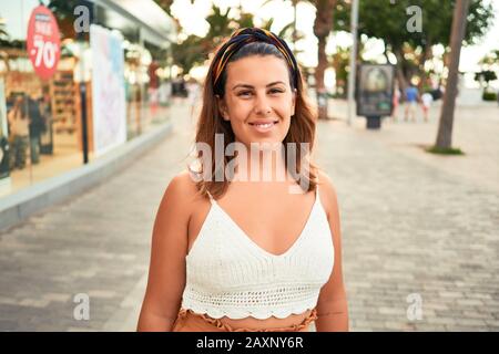 Giovane bella donna sorridente felice camminando sulle strade della città di Puerto de la Cruz Tenerife da una giornata di sole di estate Foto Stock