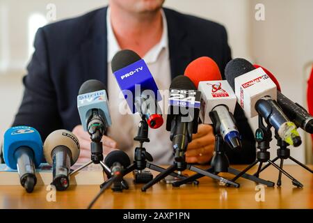 Bucarest, Romania - 12 febbraio 2020: L'uomo tiene una conferenza stampa e parla in vari microfoni rumeni delle televisioni di notizie. Foto Stock
