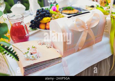 Bellissimi fiori e un album fotografico su un tavolo bianco Foto Stock