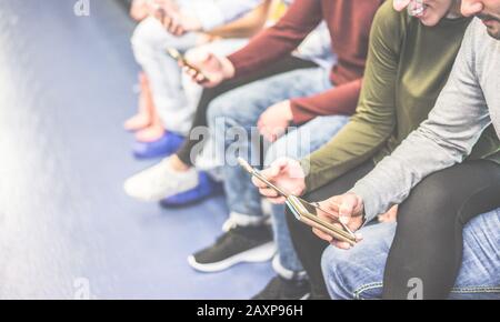 Gruppo di amici che utilizzano i telefoni cellulari in metropolitana - Concetto di dipendenza della gente alle tendenze tecnologiche - momento di alienazione per il problema di nuova generazione Foto Stock