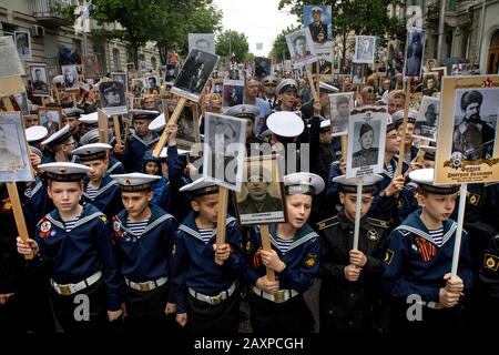 Sevastopol, Crimea, 9th di Maggio, 2019 i Cadetti della Scuola Navale di Nakhimov tengono ritratti con i partecipanti di fotografia della Grande Guerra Patriottica durante l'azione il Reggimento Immortal nella città di Sevastopol Foto Stock