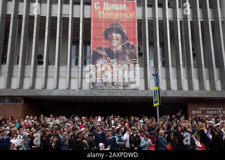 Sevastopol, Crimea, 9th di maggio 2019 La Gente guarda una parata militare del giorno della vittoria su Nakhimova Avenue che segna il 74th anniversario della vittoria sulla Germania nazista nella Guerra Patriottica del 1941-45, il fronte orientale della seconda guerra mondiale nella parte centrale della città di Sevastopol Foto Stock