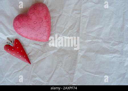 San Valentino, piccolo cuore di fragola con cuore rosa fiorito su sfondo bianco carta avvolgente. Primo piano, posizionare il testo. Foto Stock