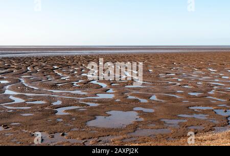 Fango nel lavaggio durante la bassa marea a Snettisham, Norfolk. Foto Stock