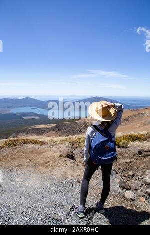 Escursionista femminile, indossando leggini e cappello, guardando il paesaggio naturale Foto Stock