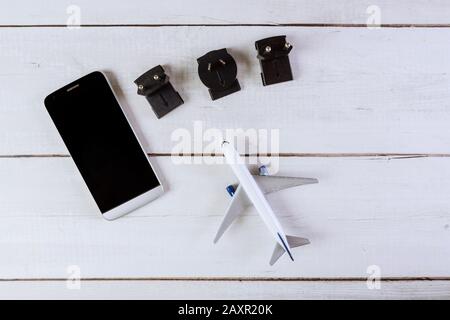 Utilizzato per il collegamento a diverse prese elettriche adattatori prese modello mondiale aereo su piatto e smartphone Foto Stock