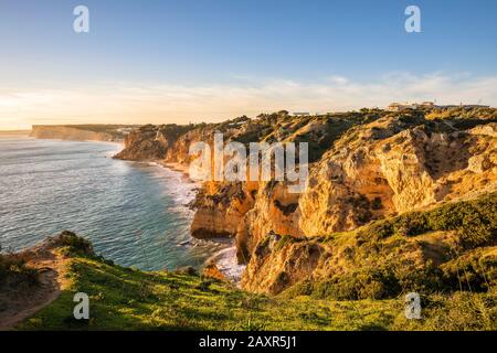 Costa rocciosa a Praia do Canavial al tramonto, Lagos, Algarve, Faro distretto, Portogallo Foto Stock