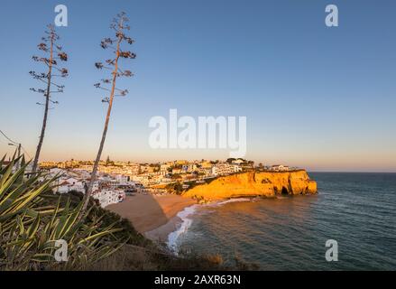 Spiaggia e città Carvoeiro al tramonto, Algarve, Faro distretto, Portogallo Foto Stock