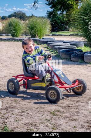 ridendo ragazzo su una pedaliera rossa Foto Stock