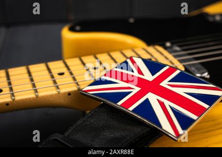 Chitarra elettrica classica americana con chiusura metallica della bandiera britannica "Union Jack" sulla tracolla Foto Stock