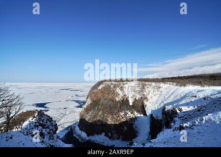 Ampia vista ad ampio angolo delle cascate di Furepe, del promontorio di utoro, del faro di utoro e del mare di okhotsk ricoperto di ghiaccio e neve alla deriva in inverno, Shiretoko, il Scicli Foto Stock