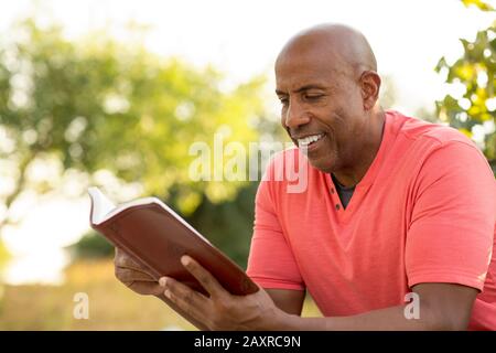 African American uomo pregare e leggere la Bibbia. Foto Stock