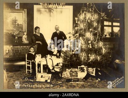 18919, GERMANIA : Famiglia con figli, sotto l'albero di Natale decorato e con doni portati da Babbo Natale . FOTO DI WASSERMANN - NATALE - GIOCO - NATALE - GIOCO - BABBO NATALE - SANTA KLAUS - IMMAGINE NATALIZIA - WEIHNACHTEN - FOTO STORICHE - BAMBINO - BAMBINI CHE GIOCANO - BAMBINI - BAMBINI - BAMBINI - INFANZIA - INFANZIA - INFANZIA - NOVECENTO - XX SECOLO - '900 - '900 - '900 - gioia - gioia - gioia - gioia - gioia - gioia - divertimento - gioco - INVERNO - inverno - Babbo Natale - GERMANIA - ALBERO DI NATALE - FAMIGLIA - NOTTE DI NATALE - ALBERO ADDOBBAT Foto Stock