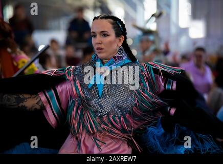 San Francisco, USA - 08 febbraio 2020: Madre americana indiana donna vestita con un intricato stile tradizionale shawl danza vestito a un powow Foto Stock