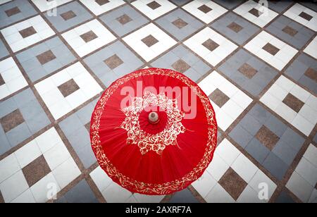 Donna con ombrello rosso tailandese al piano a scacchi presso Wat Doi Suthep a Chiang mai, Thailandia. Vista dall'alto. Foto Stock
