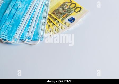 Maschere mediche e banconote da 200 euro come simbolo di un aumento dei prezzi per la protezione del tratto respiratorio dai virus. Ci è un posto per copyspace Foto Stock