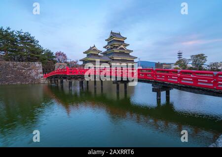 Nagano, Giappone - 13 aprile 2018: Castello di Matsumoto al crepuscolo con il ponte rosso a Nagano, Giappone. Foto Stock