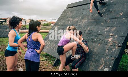 Partecipanti femminili in ostacolo percorso arrampicata piramide ostacolo Foto Stock