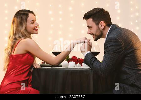 Gallant Man Kissing Fidanzata Mano Su Romantic Date In Restaurant Foto Stock