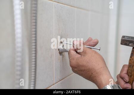 Uomo asiatico cerca di fissare e tubo di riparazione / doccia nella vecchia toilette. Foto Stock