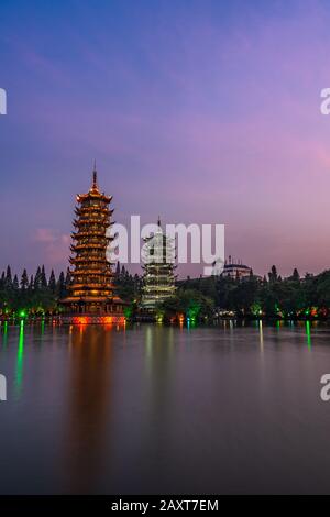 Sun and Moon Pagodas Towers a Shanhu o Shan Lake nella città di Guilin illuminata da luci colorate di notte, Provincia Guangxi, Cina Foto Stock