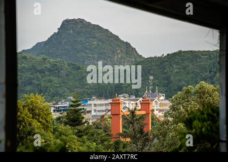 Ponte rosso su via Sanduo Lu nella città di Guilin con montagne carsiche sullo sfondo, provincia Guangxi, Cina Foto Stock