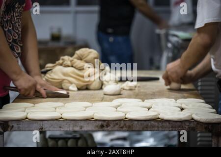 Uomo e donna che fanno pane da pasta di farina in una piccola panetteria locale sulla strada nel quartiere musulmano, Xian città, Cina Foto Stock