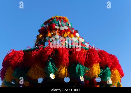 Cappello iconico e colorato di un tradizionale venditore di acqua a Marrakech, Marocco, contro il cielo blu. Foto Stock