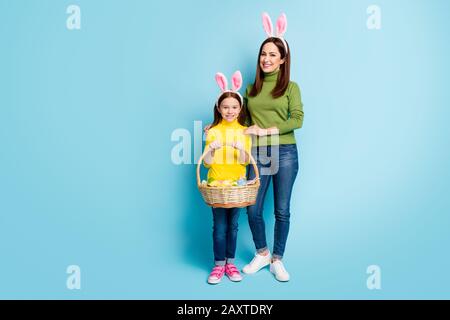 Full lunghezza dimensioni del corpo vista di bella attraente bella allegra ragazze allegre che trasportano festive cesto celebrativo aprile isolato su luminoso brillante brillante brillantezza Foto Stock