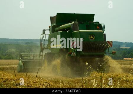 Raccolta di grano vicino a Duras, Lot-et-Garonne, Francia con una mietitrebbia John Deere T670 Hillmaster. Foto Stock