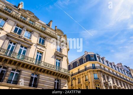 Vista ad angolo basso dei tipici edifici residenziali in stile Haussmann nei quartieri chic di Parigi, Francia, in una giornata di sole contro il cielo blu. Foto Stock