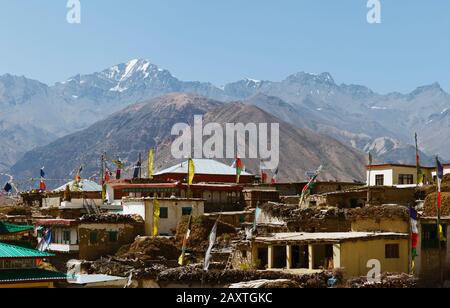 L'antico villaggio di Nako si contrappone all'alta Himalaya e alle bandiere di preghiera buddiste in primo piano in estate a Nako, Himachal Pradesh, India. Foto Stock