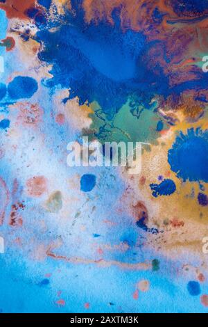 Gocce con striature di colori diversi di vernice vengono miscelate e assorbite. Macchie di vernice astratte su carta bianca Foto Stock