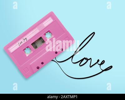 nastro per audiocassette rosa con etichetta tag amore canzone aggrovigliata nastro parola amore isolato su sfondo blu, vista dall'alto. Foto Stock