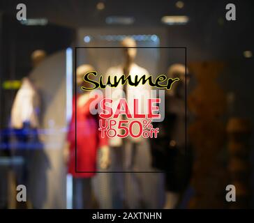 segno sconto di vendita di estate 50 per cento con esposizione blurry di uno showroom di negozio di abbigliamento in background. stagione di vendita di estate o promozione di vendita di liquidazione Foto Stock