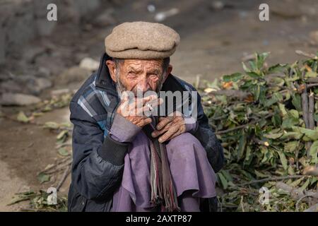 fumare l'uomo anziano in abiti tradizionali Foto Stock