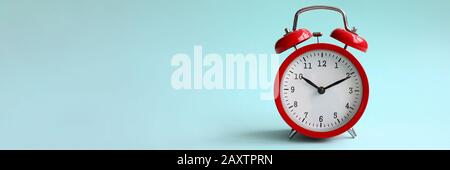 Sveglia rossa su sfondo turchese mostra Foto Stock